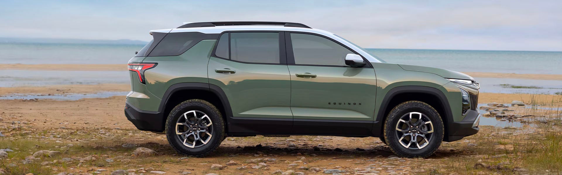 Green Chevrolet Equinox parked on the beach during a cloudy day