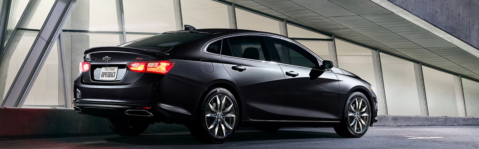 Black Chevrolet Malibu parked in the middle of the garage during the day