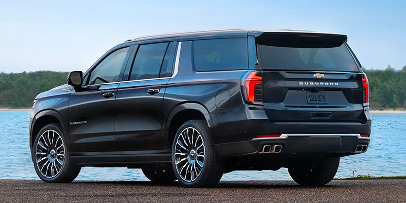 Blue Chevrolet Suburban parked near a dock next to a big ocean
