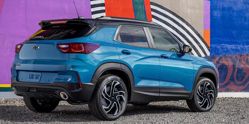 Blue Chevrolet Trailblazer parked on a street next to a mural