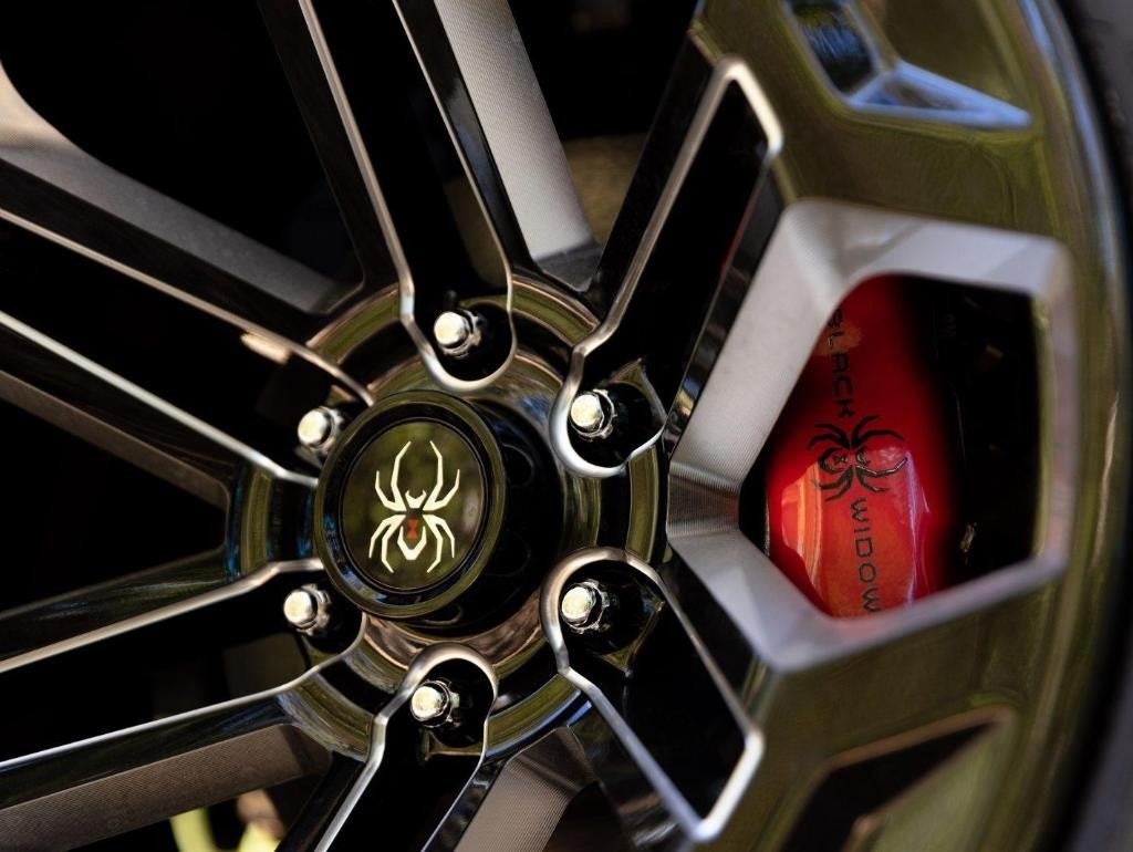 Black Widow wheel with spider emblem and red caliper detail.