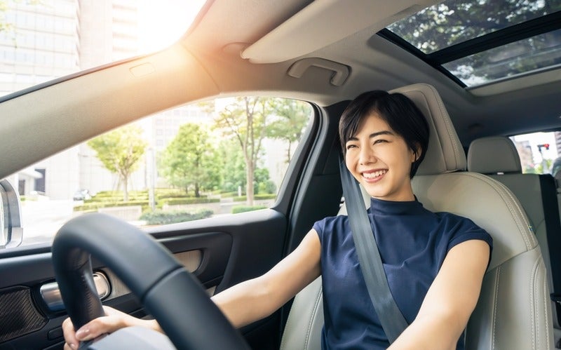 Woman smiling while driving a car.